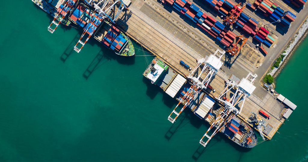 Schiffe und Container mit Exportgütern an einem Hafen